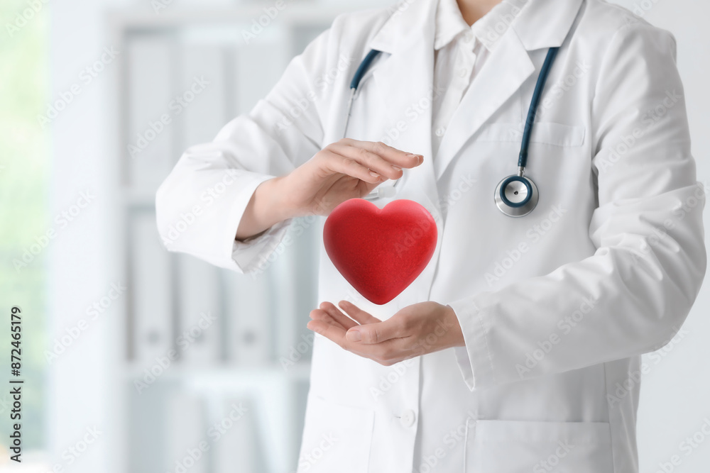 Doctor holding red heart in clinic, closeup Doctor holding red heart in clinic, closeup