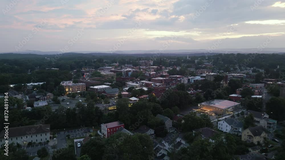 Warm lights glow over calm peaceful New England hill town at sunset dusk Warm lights glow over calm peaceful New England hill town at sunset dusk