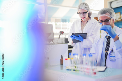 scientists perform experiments and record data. people arranges equipment with test tubes and chemicals for producing medicine and biochemistry. man hold tubes of chemical liquids and plant samples.