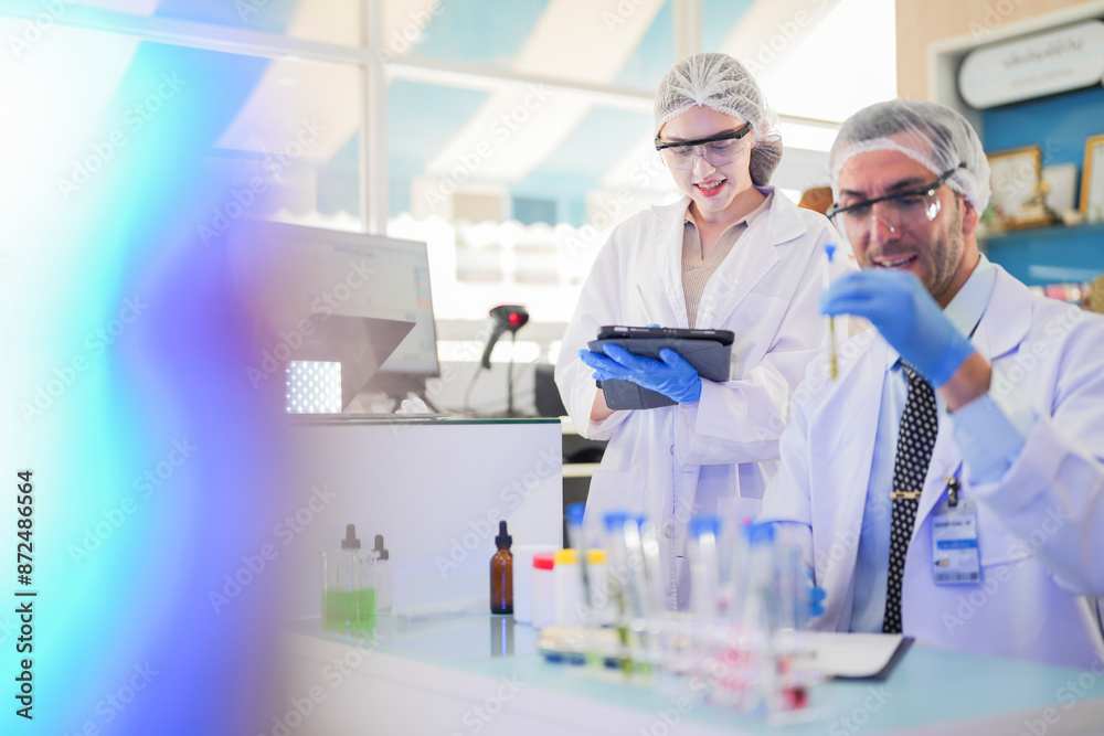 scientists perform experiments and record data. people arranges equipment with test tubes and chemicals for producing medicine and biochemistry. man hold tubes of chemical liquids and plant samples. scientists perform experiments and record data. people arranges equipment with test tubes and chemicals for producing medicine and biochemistry. man hold tubes of chemical liquids and plant samples.