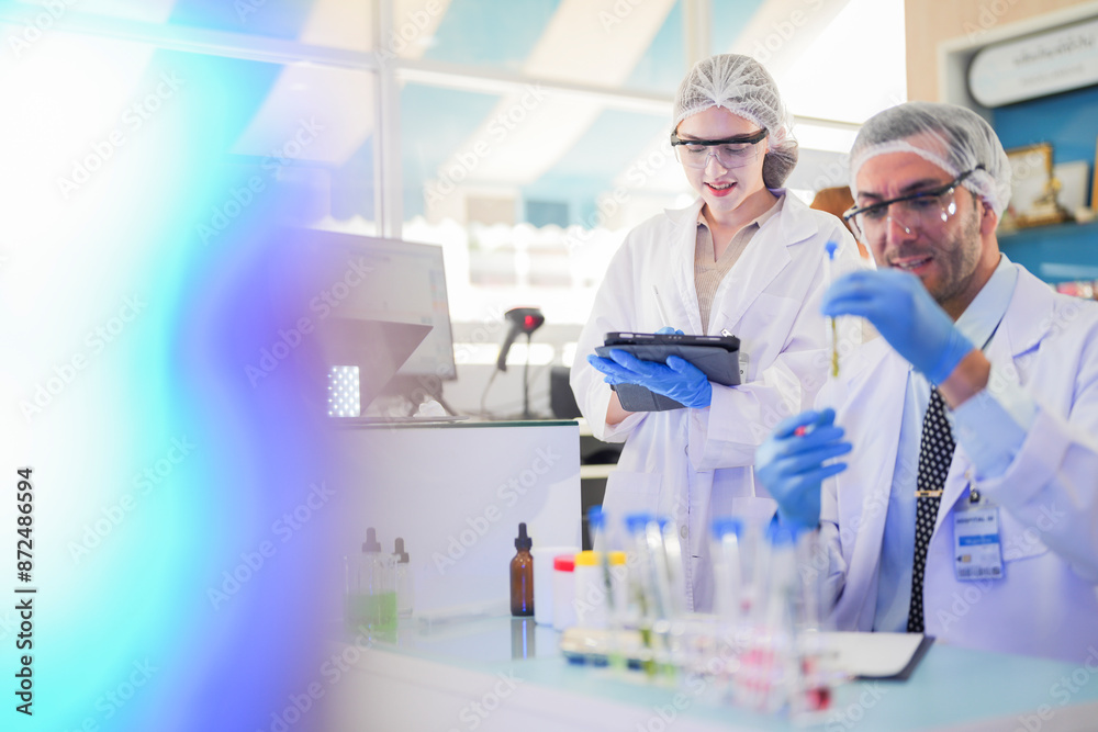 scientists perform experiments and record data. people arranges equipment with test tubes and chemicals for producing medicine and biochemistry. man hold tubes of chemical liquids and plant samples. scientists perform experiments and record data. people arranges equipment with test tubes and chemicals for producing medicine and biochemistry. man hold tubes of chemical liquids and plant samples.