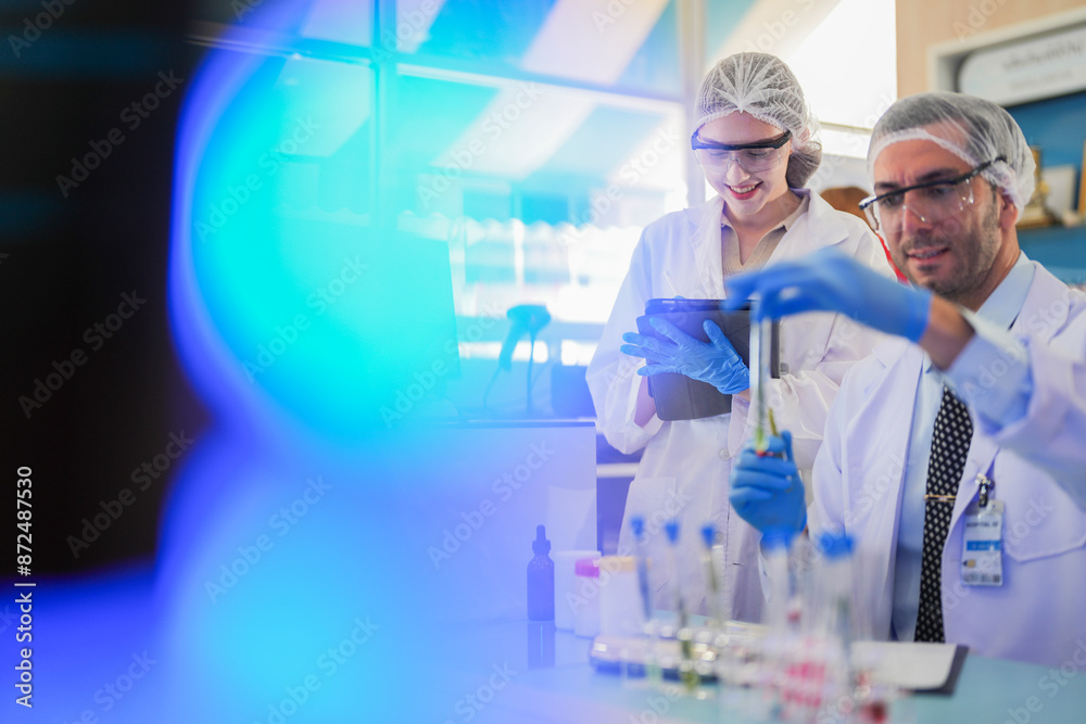 scientists perform experiments and record data. people arranges equipment with test tubes and chemicals for producing medicine and biochemistry. man hold tubes of chemical liquids and plant samples. scientists perform experiments and record data. people arranges equipment with test tubes and chemicals for producing medicine and biochemistry. man hold tubes of chemical liquids and plant samples.