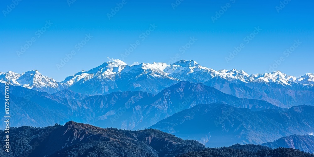 Fototapeta premium A breathtaking view of snow-capped mountains against a clear blue sky on a crisp winter day