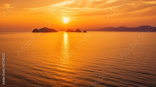 Stunning Sunset Over Calm Ocean with Silhouetted Islands and Vibrant Orange Sky