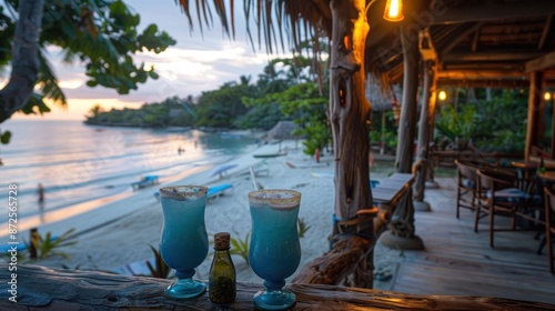 Fototapeta Naklejka Na Ścianę i Meble -  Two drinks in blue glasses on a wooden table overlooking the ocean