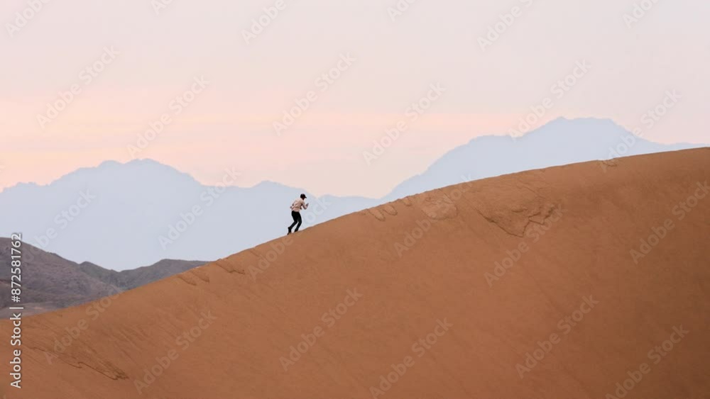 Man walking, climbing the barchan in the desert, Singing barchans, Kazakhstan, Altyn Emel, desert, steppe, sand | Человек идёт, поднимается на бархан в пустыне, Поющие барханы, Казахстан, Алтын Эмель,