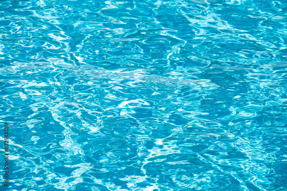 Ripple Water in swimming pool with sun reflection. Wavy water background.