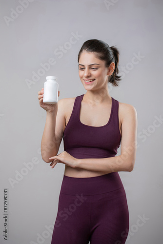 Wallpaper Mural Sports Model Is Looking At Tablet Bottle That She Is Holding In Her Hand Torontodigital.ca