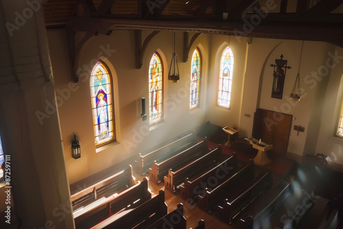 Window light is shing on rows of empty church pews in a Church Sanctuary without any people in it.