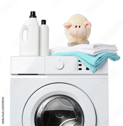 White Laundry Detergent Bottles, Sheep Toy, and Towels on Top of a White Washing Machine photo