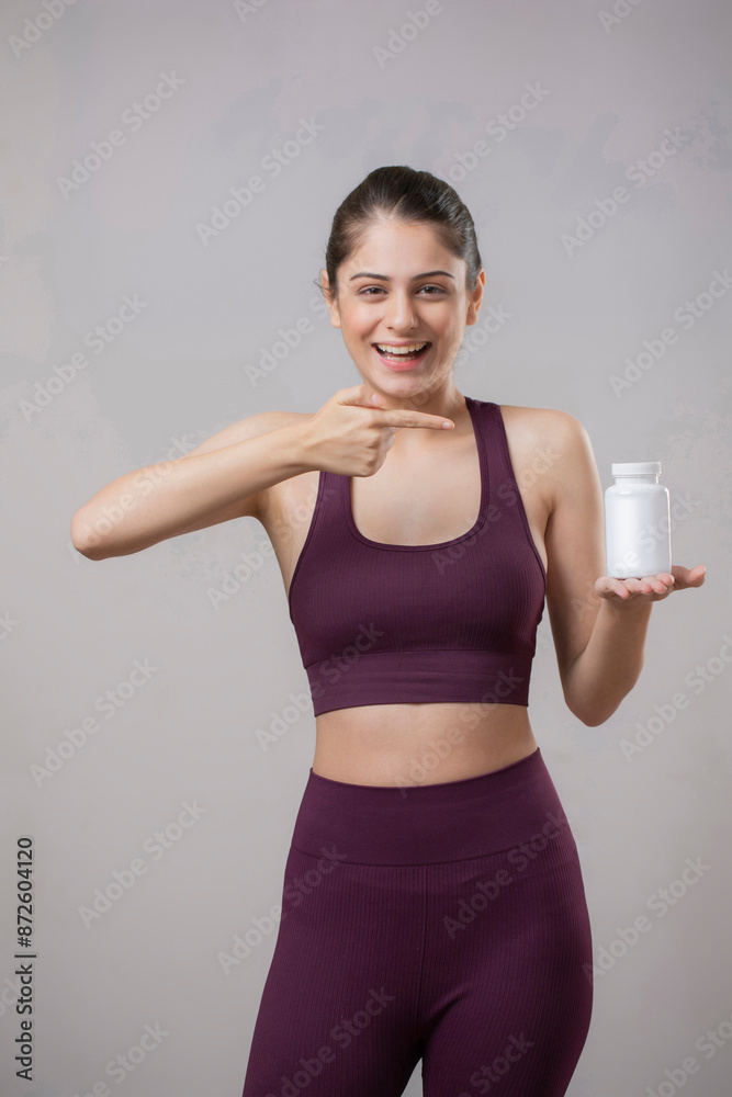 Lovely Model Laughing While Pointing Finger At The Tablet Bottle Lovely Model Laughing While Pointing Finger At The Tablet Bottle
