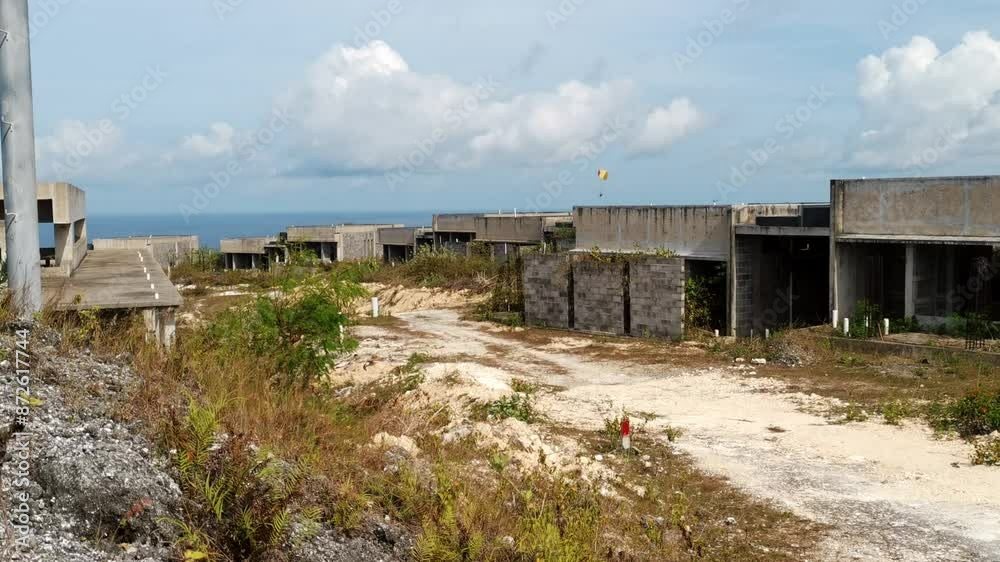 Close-up of abandoned hotel construction in desolate wasteland. Overgrown gravel roads lead to ruins with a post apocalyptic vibe. Ideal for apocalyptic projects that are reminiscent of Mad Max. Close-up of abandoned hotel construction in desolate wasteland. Overgrown gravel roads lead to ruins with a post apocalyptic vibe. Ideal for apocalyptic projects that are reminiscent of Mad Max.