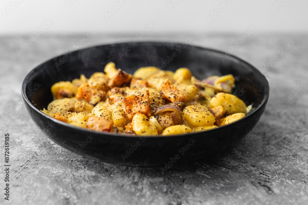 turmeric gnocchi with pumpkin and onion in creamy sauce, healthy plant-based food turmeric gnocchi with pumpkin and onion in creamy sauce, healthy plant-based food
