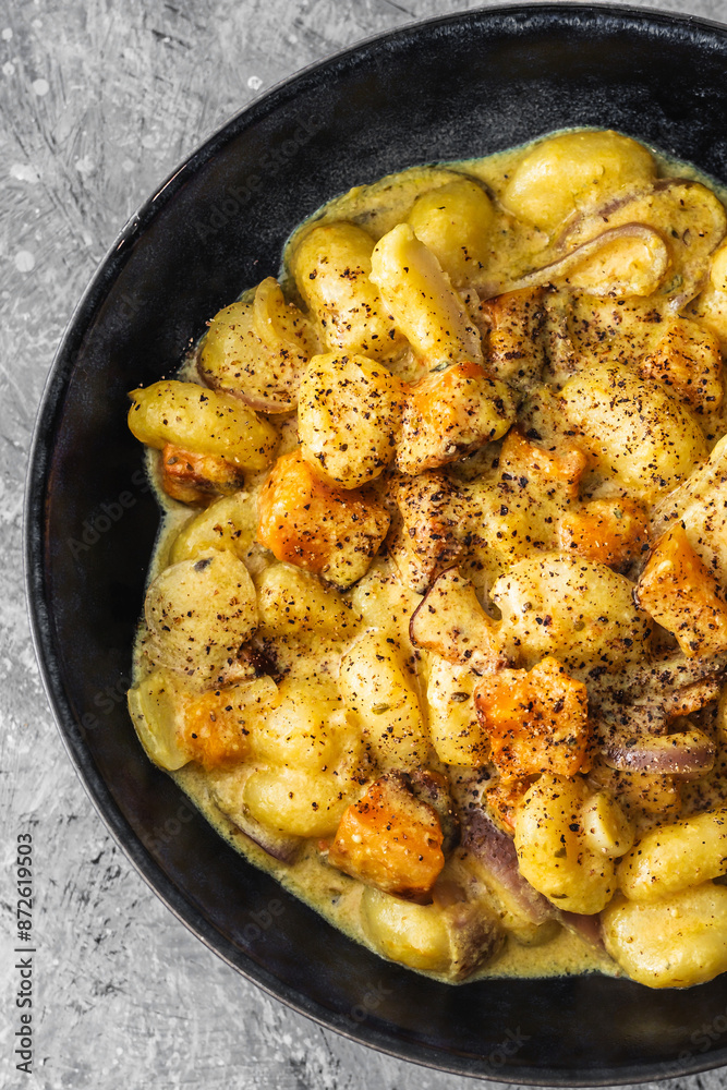 turmeric gnocchi with pumpkin and onion in creamy sauce, healthy plant-based food turmeric gnocchi with pumpkin and onion in creamy sauce, healthy plant-based food