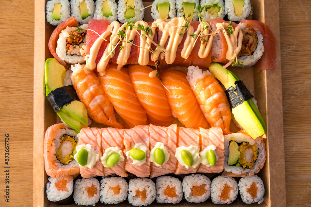 Assorted sushi with nigiri, rolls, and fresh ingredients in a cardboard box for delivery Assorted sushi with nigiri, rolls, and fresh ingredients in a cardboard box for delivery