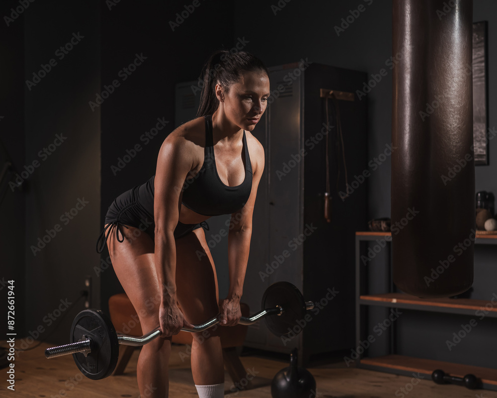 Caucasian woman doing deadlifts in retro gym. Caucasian woman doing deadlifts in retro gym.