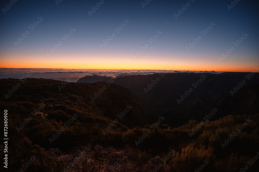 Hiking on the highest peak of Madeira Pico Ruivo next to the cottage Abrigo do Pico Ruivo. Views of the surrounding mountains lanscape during sunrise Hiking on the highest peak of Madeira Pico Ruivo next to the cottage Abrigo do Pico Ruivo. Views of the surrounding mountains lanscape during sunrise