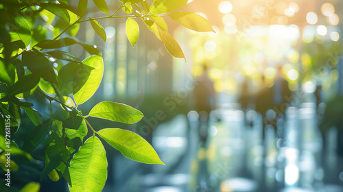 A blurred background of people walking in a modern office, surrounded by green trees and sunlight. Reflects an eco-friendly and ecologically responsible business concept.copy space