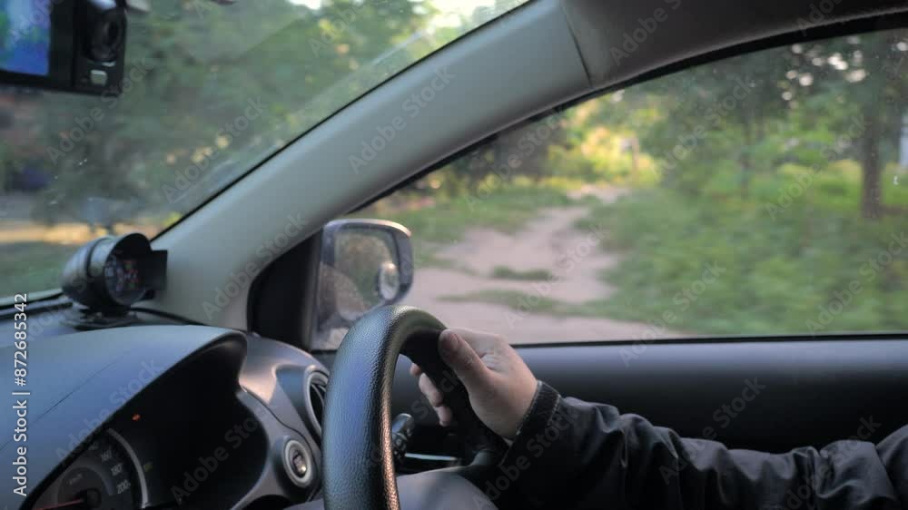 The man driving a car on the rural road. Close-up shot The man driving a car on the rural road. Close-up shot