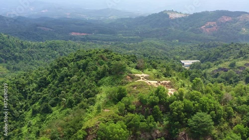 Aerial drone flyover the hilly terrain capturing the undeveloped mountain landscape of jungle forests from above at Kajang, Selangor, Malaysia. photo