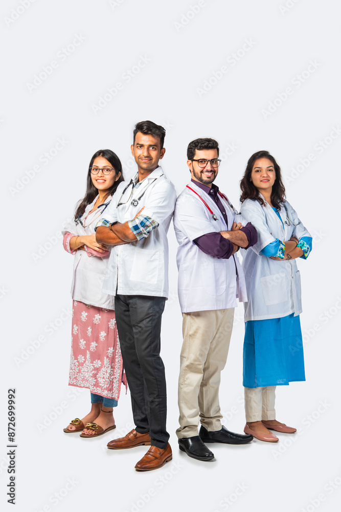 Group portrait of four indian asian young doctors in uniform standing against white background Group portrait of four indian asian young doctors in uniform standing against white background