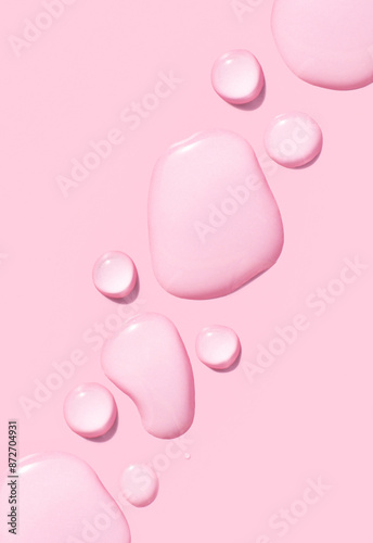 round drops of transparent gel serum on pink background © Екатерина Клищевник