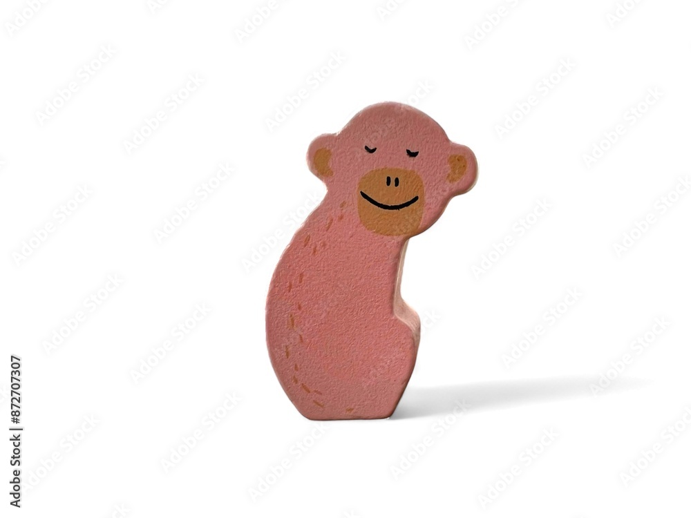 Wooden decoration with a pink monkey character on a white background Wooden decoration with a pink monkey character on a white background