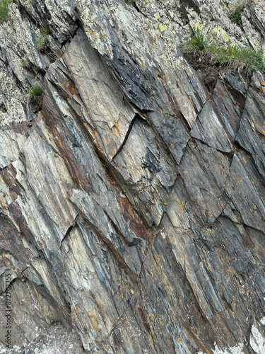 Photo of a fragment of gray and brown layered rock with pieces of moss in Kazbegi, Georgia photo