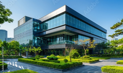 A modern office building with glass windows and green landscaping