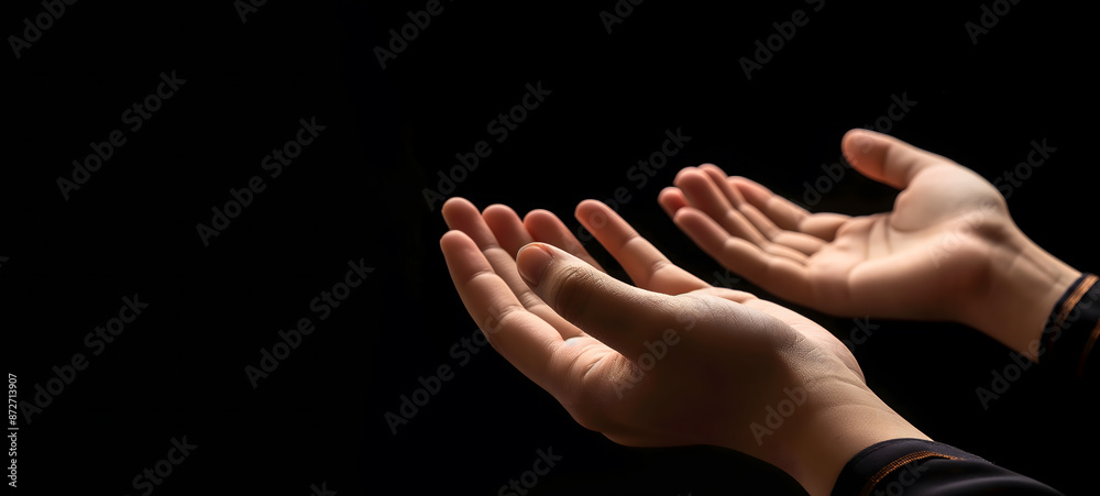 Fototapeta premium Praying Hands with White Embroidered Robe Against Dark Background
