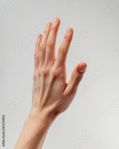 Close-up of a person's hand reaching up with a neutral background. Perfect for concepts of help, request, or gesture. © NiriSun