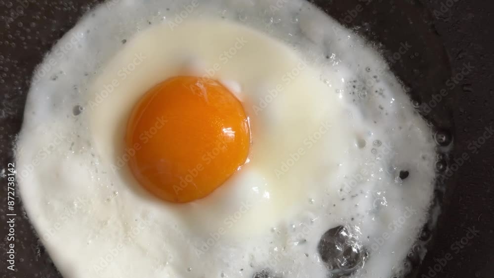 Scrambled eggs are fried in a frying pan in oil. Scrambled eggs are fried in a frying pan in oil.