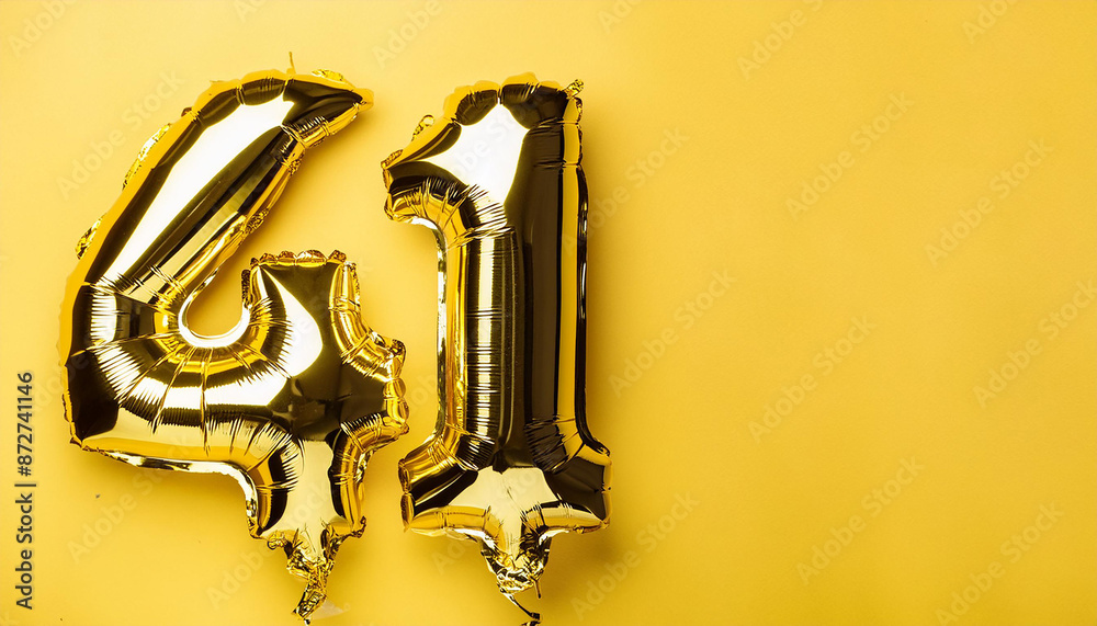 Banner with number 41 golden balloon. 41 years anniversary celebration. Yellow background. Close-up. Banner with number 41 golden balloon. 41 years anniversary celebration. Yellow background. Close-up.