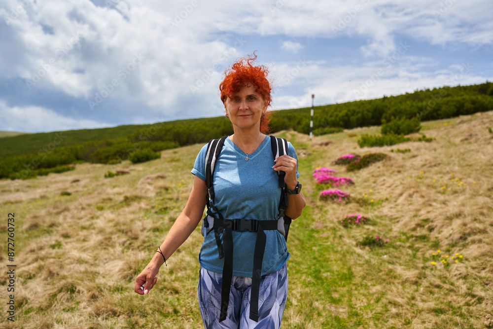 Woman hiking on a mountain with rhododendron flowers Woman hiking on a mountain with rhododendron flowers
