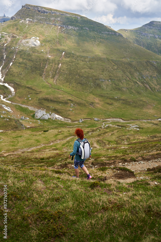 Naklejka premium Woman hiking in the mountains with backpack