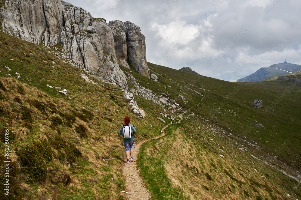 Fototapeta premium Woman hiking in the mountains with backpack