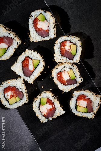 A set of maki rolls with salmon, cucumber, shrimp in a black package. Photo for delivery