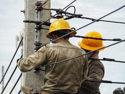 Lineworkers installing repairing and maintaining overhead power lines, aerial cabling and telecommunications.