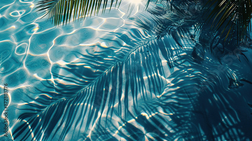 Tropical leaf shadow on water surface. Shadow of palm leaves on blue water. Beautiful abstract background concept banner for summer vacation at the beach © Uwe