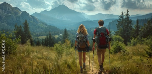 Two Hikers Walk Through Grassy Path in Mountain Landscape