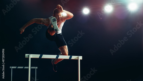 Male Athlete in Mid-air, Leaping Over Hurdle Under Bright Stadium Lights. Agility, Strength, and Determination in High-energy Track and Field Championship Event.