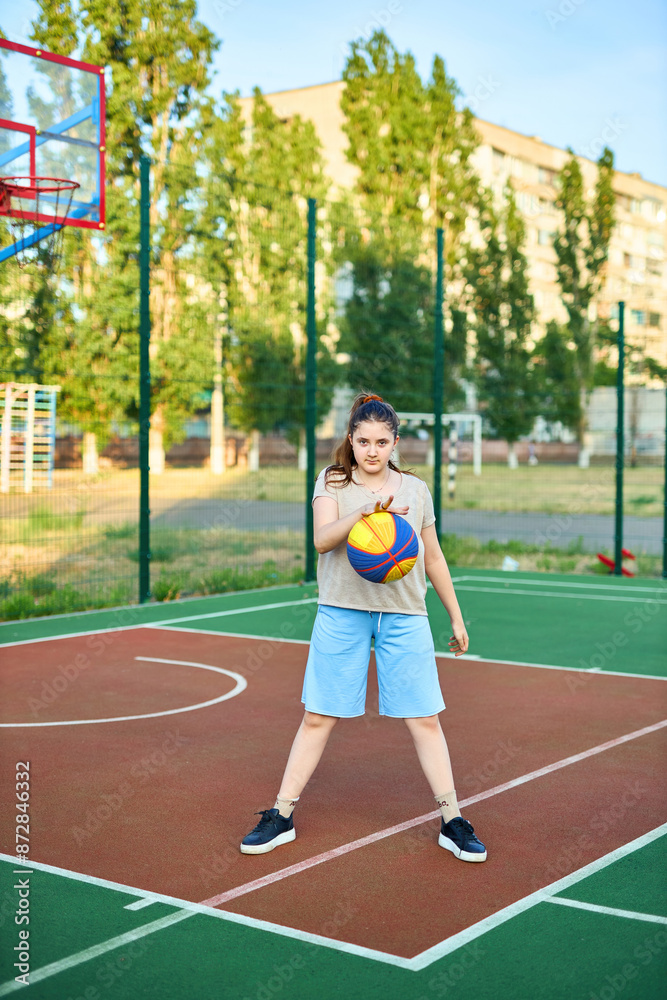 Obraz premium Lifestyle portrait of Cheerful caucasian little girl ten years old holding game ball