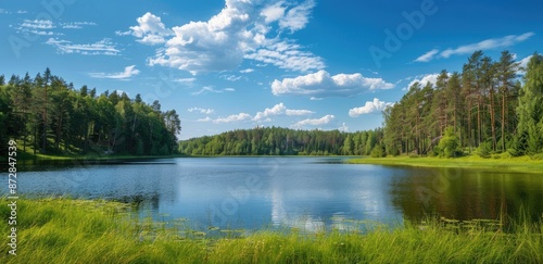 Serene Lake Surrounded by Lush Green Forest © andri