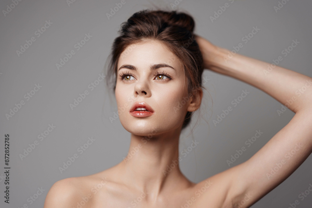 Young woman posing with hands on head on gray background Young woman posing with hands on head on gray background