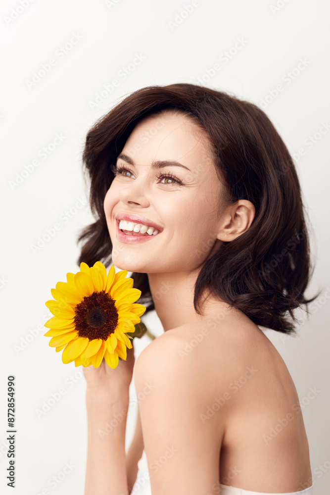 Beautiful young woman posing with a sunflower on a white background Beautiful young woman posing with a sunflower on a white background