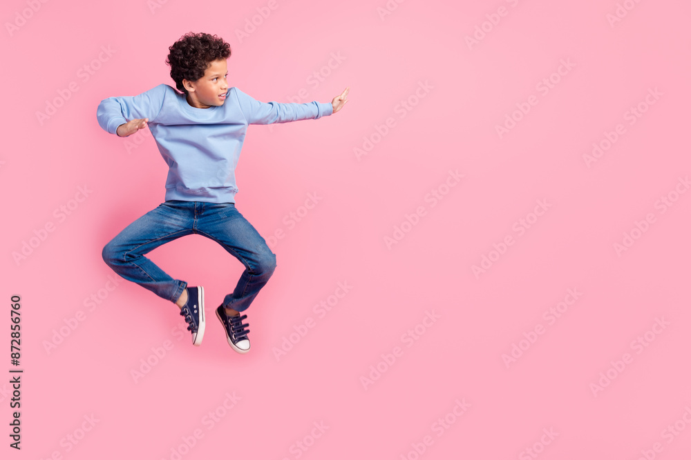 Full length photo of handsome good mood grandson wear blue sweater jumping high beating emtpy space isolated pink color background Full length photo of handsome good mood grandson wear blue sweater jumping high beating emtpy space isolated pink color background