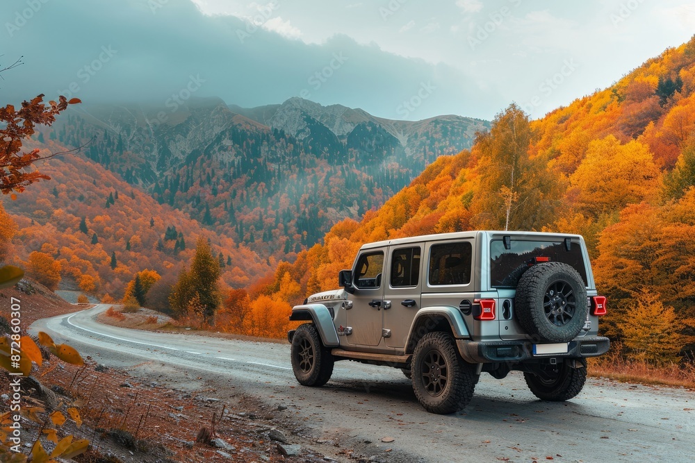 High passable vehicle parked on an asphalt road in the mountains with a forest painted in autumn colors High passable vehicle parked on an asphalt road in the mountains with a forest painted in autumn colors