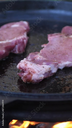 Pan-frying a steak in the woods over a campfire