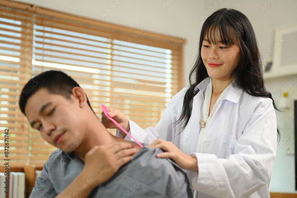 Fototapeta premium Physiotherapy specialist applying kinesio tape on the shoulders and neck of athlete patient. Sport physical therapy concept