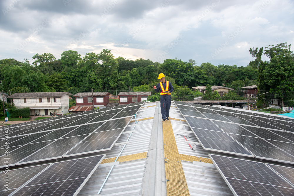 Fototapeta premium A solar panel installation company employee assembles a photovoltaic system on the roof.